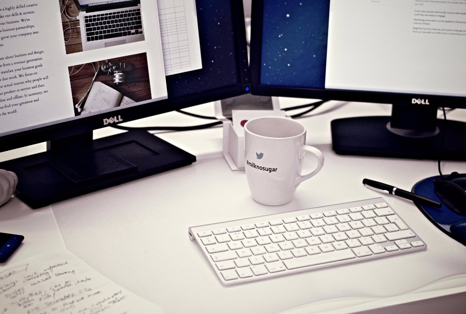 Minimal white desk with keyboard and monitor